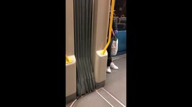Woman in metro scrolls on smartphone wearing gloves