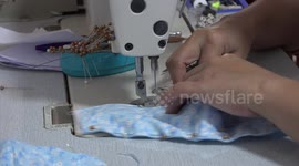 A lady uses a sowing machine to make protective face masks in Thailand.