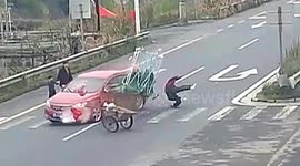 Distracted motorist in China crashes into pedestrian walking across road with handcart