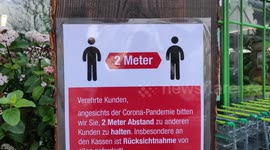 German supermarkets hang up warning posters about coronavirus to ask people to keep a minimum distance