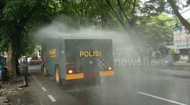 Indonesian police lowered 2 water canons to spray the disinfectant onto the main road in Padang City
