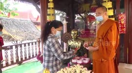 Thai Buddhist monks give lucky charms to devotees to protect them from Covid-19