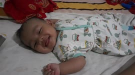 He is having a nice dream, laughing, and acting peace.