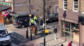 London police officer instructs customer to wait outside bakery while another is served during lockdown