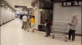 Malaysian shoppers respect social distancing rules while queuing outside shop in Malacca