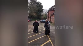 Monks entertain students in self-isolation by dancing in UK college car park