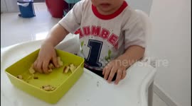 Playful toddler turns a layer of cake into pieces