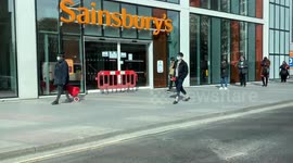 Londoners maintaining social distancing advice at a queue for a Sainsbury’s supermarket