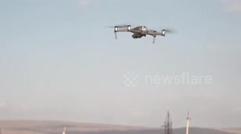 A Georgian policeman wearing a protective mask operates a drone in Marneuli