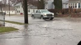 Vehicles drive through flooded road in Sioux Falls, South Dakota