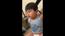 Toddler pretends to be sleeping while mother tells him off