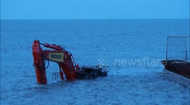 Excavator working on sea defenses gets caught out by tide!