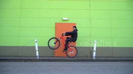 Funny Mountainbike MTB Wheelie in front of Colorful urban building