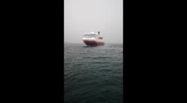 Coastal cruise steamer arrives in Arctic Norways far eastern corner during a storm.