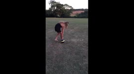 Teenage girl spins around a football then kicks it into camera
