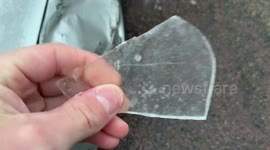 US driver has to kick incredibly thick layer of ice off his car