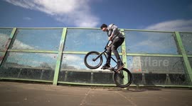 Man Jumping on a BMX Bike next to a highway with high traffic