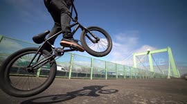 Man jumping with BMX Bike on highway bridge next to traffic