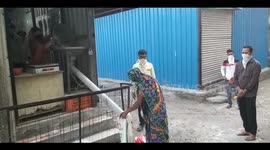 Indian shopkeeper dispenses food via plastic tube to maintain social distance during COVID-19 lockdown