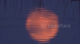 Full Pink Supermoon hypnotically reflected in water in Kent, UK