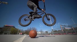 Cool man jumps over Basketball with BMX Bike from left to right / 120fps Slowmo / Outdoor Action & Fun Sports