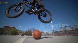 Young man jumps over Basketball with BMX Bike from right to left / 120fps Slowmo / Outdoor Action & Fun Sports