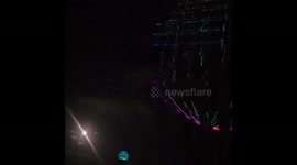 Very large laser orb being projected onto very large tree.