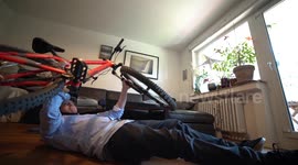 Young man working out with Mountainbike in Home Office during Corona Quarantine (funny)