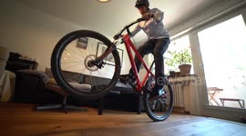 Young man jumping with Mountainbike in Home Office during Corona Quarantine (funny)