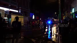 People applauding firefighters in appreciation for their work, a 1912 building destroyed in fire after the protests