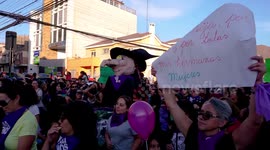 Gigantic march for women's day in Chile, women singing and dancing while carrying a witch doll