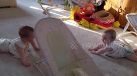 Eight-month-old twin sisters giggle as they recognise each other for the first time