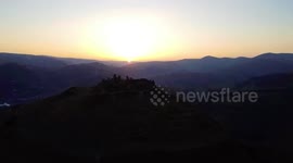 Drone footage captures picturesque sunset as it silhouettes medieval castle in Wales