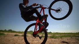 Mountain Biker does crazy steep wheelie / almost falling and hitting camera