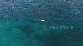 Drone footage of person fishing from a paddleboard