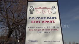 Crowds of people on Toronto beaches boardwalk defying law requiring them keep two meters physical distancing during COVID 19 even though signs are placed every 100 feet