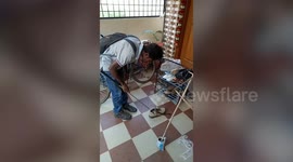 Scary moment rescuer pulls out deadly cobra from person's shoe in south India