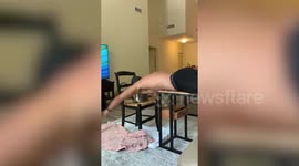 American fitness enthusiast practises swimming on table at home during coronavirus lockdown