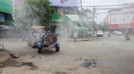 Tractor sprays COVID-19 sanitising liquid on the street in Battambang, Cambodia