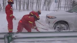 Chinese firefighters rescue people from cars that were trapped on snow-covered road due to powerful blizzard