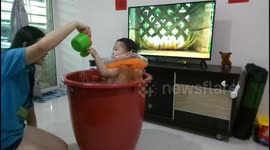Toddler enjoys playing his homemade baby spa with his mum during coronavirus quarantine