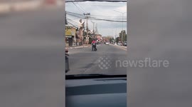 Food delivery rider stops traffic to help frail pensioner cross road in Thailand