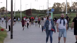 people out along the beach promenade for the first day of exercise after 7 weeks of lockdown in barcelona, spain