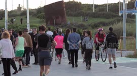 people out along the beach promenade for the first day of exercise after 7 weeks of lockdown in barcelona, spain