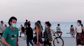 people out along the beach promenade for the first day of exercise after 7 weeks of lockdown in barcelona, spain
