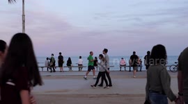 people out along the beach promenade for the first day of exercise after 7 weeks of lockdown in barcelona, spain