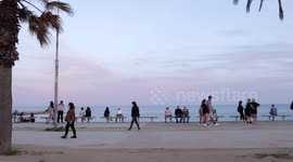 people out along the beach promenade for the first day of exercise after 7 weeks of lockdown in barcelona, spain