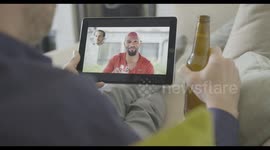 Male Friends having video call with drinks from home using video conferencing technology during social distancing lock down during covid-19