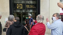 Customers appear to violate social distance guidelines while queueing outside banks in Greece