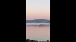 Super moon on a pink morning over Loch Long in Argyll Scotland